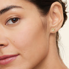 Gold twist heart moissanite stud earring worn on the ear