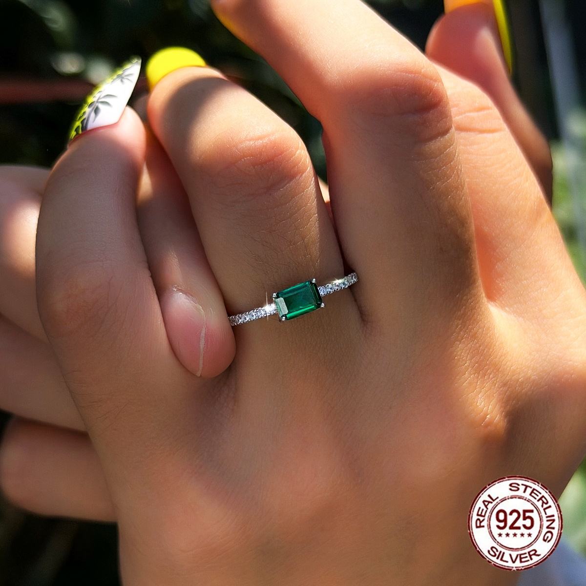 Sterling silver ring with a green emerald-cut center stone