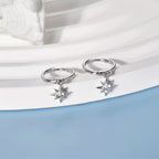 Sterling silver huggie hoops with a starburst charm