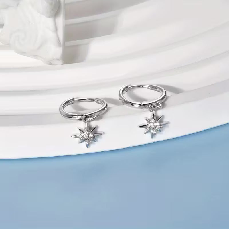 Sterling silver huggie hoops with a starburst charm